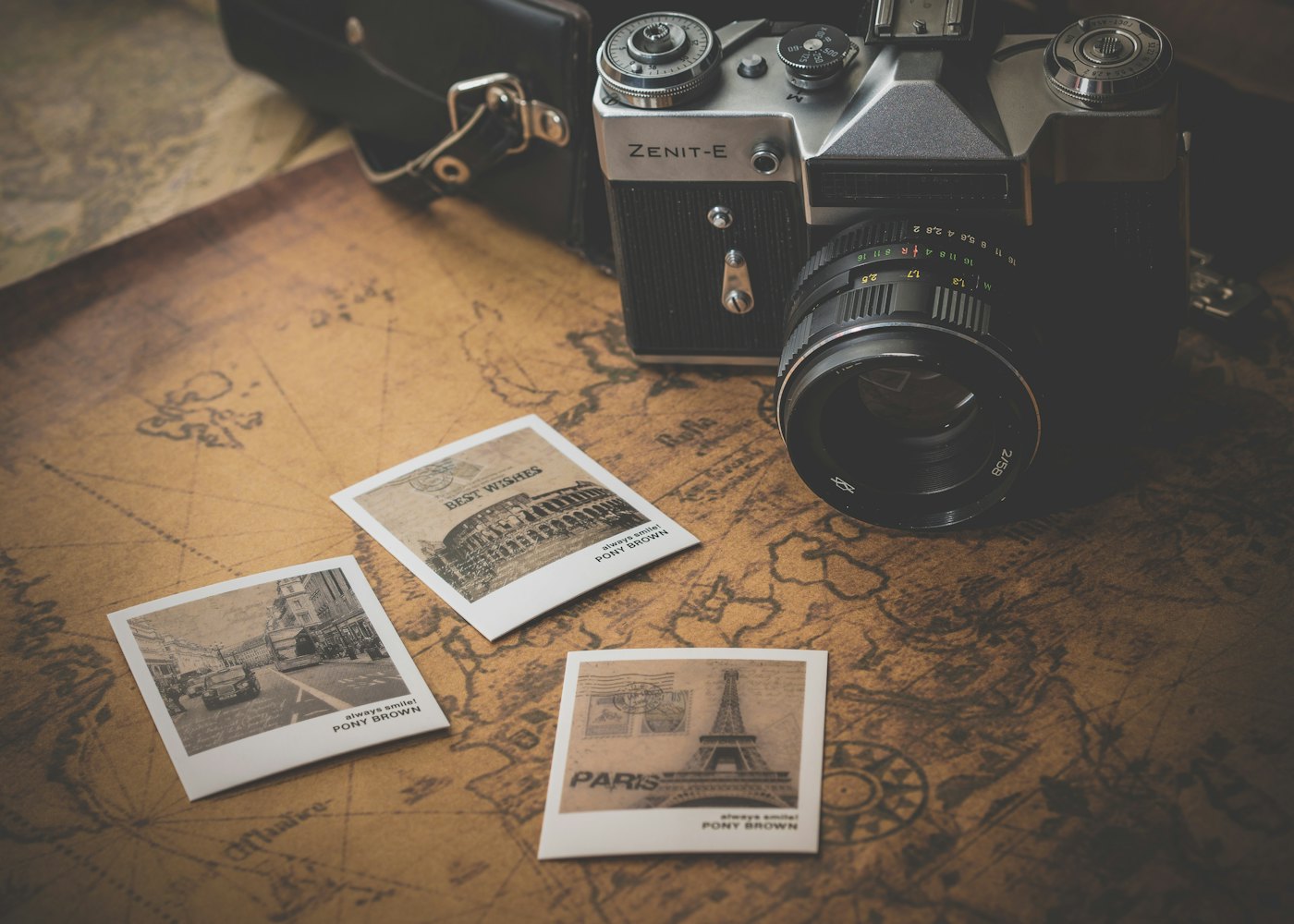 Eine alte Kamera liegt auf Urlaubsfotos